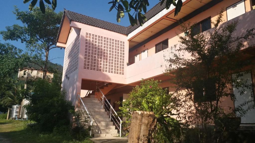 a pink building with stairs in front of it at The 99 Inn Hotel in Ban Sao Thong