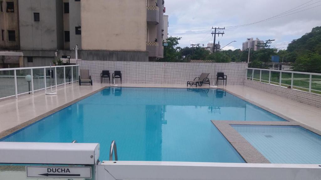 - une grande piscine bleue au-dessus d'un bâtiment dans l'établissement Floresta - Enseada Guarujá, à Guarujá