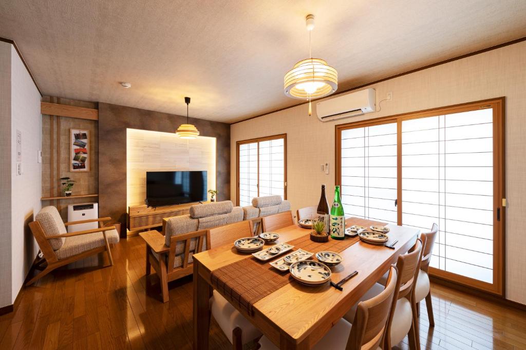 a dining room with a table and a living room at Shirakabanoyado - Ryogetsu in Osaka