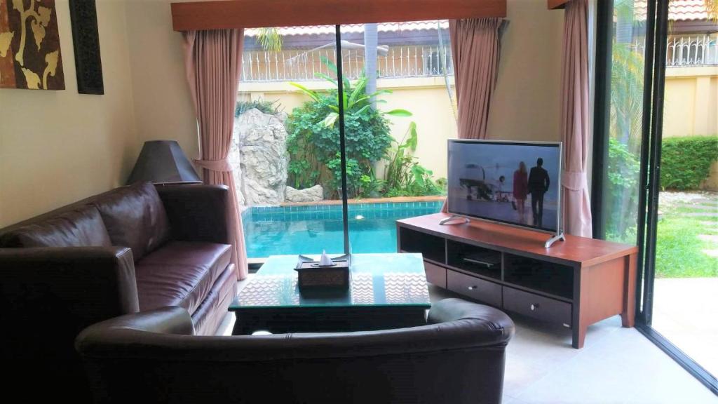 uma sala de estar com um sofá e uma televisão em View Talay Holiday Resort em Praia de Jomtien
