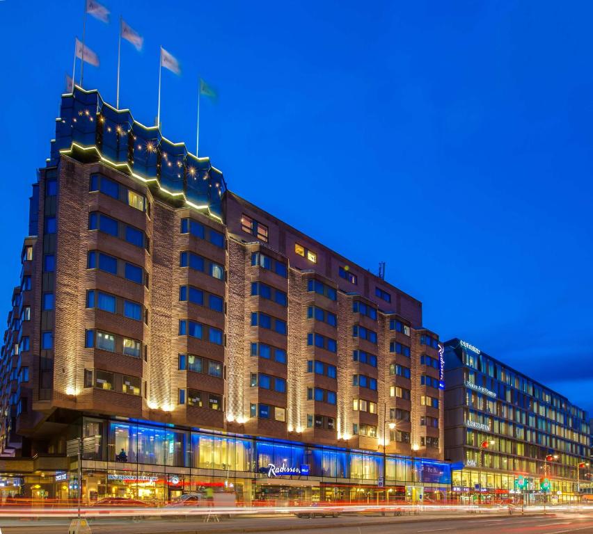 un edificio con bandiere sopra di esso di notte di Radisson Blu Royal Viking Hotel, Stockholm a Stoccolma