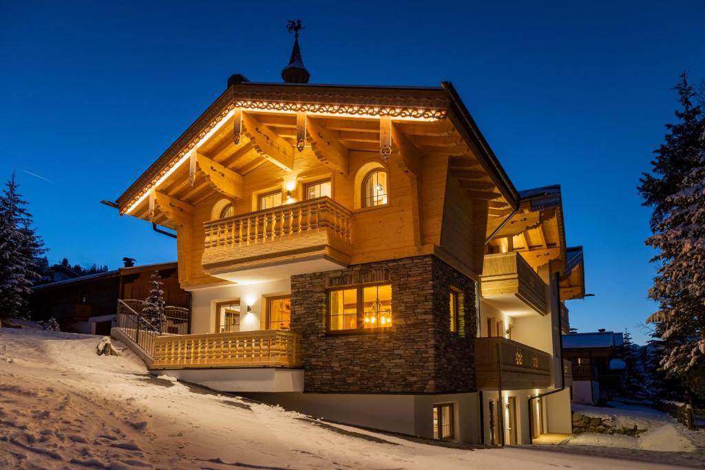 een groot houten huis in de sneeuw 's nachts bij Falkensteinalm Hochkrimml in Krimml
