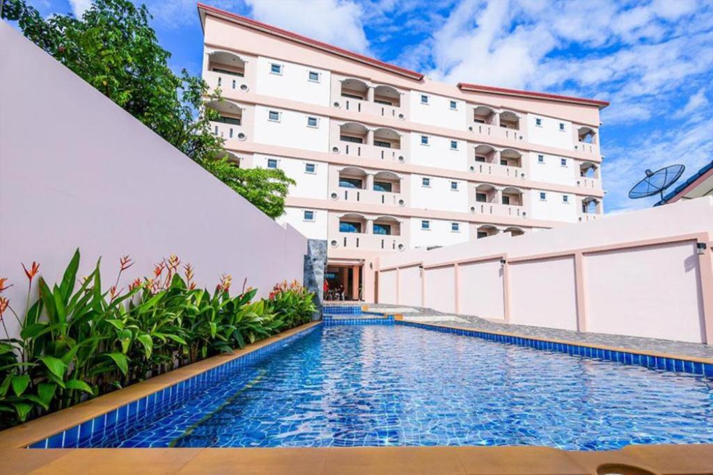 un hotel con piscina frente a un edificio en Saiyuan Residence, en Kata Beach