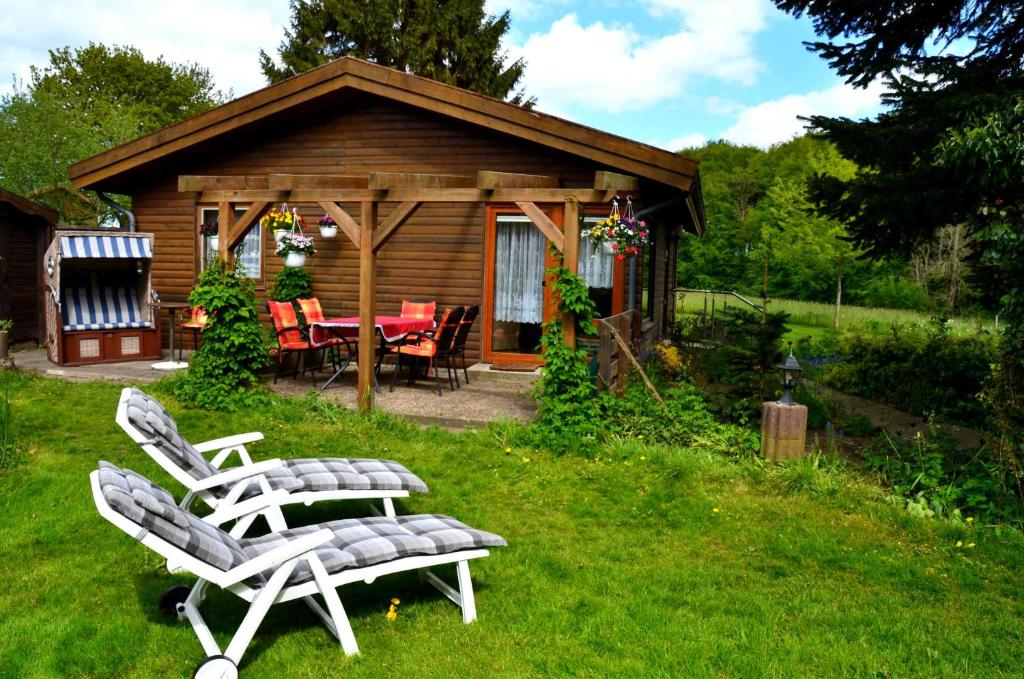 a couple of chairs and a table in front of a cabin at Ferienhaus Fischer in Sörup