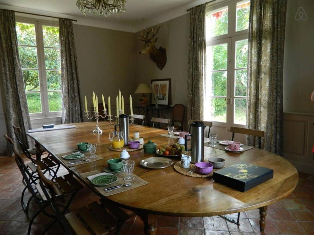 una gran mesa de madera en una habitación con comedor en La Foutelaie, en Clefs