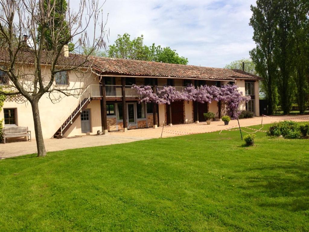 una casa con un árbol florido en el patio en Les Barelles en Saint-Jean-de-Thurigneux