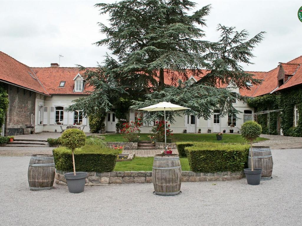 uma casa com um guarda-chuva e três barris em La Ferme de la Sensée em Gouy-sous-Bellonne