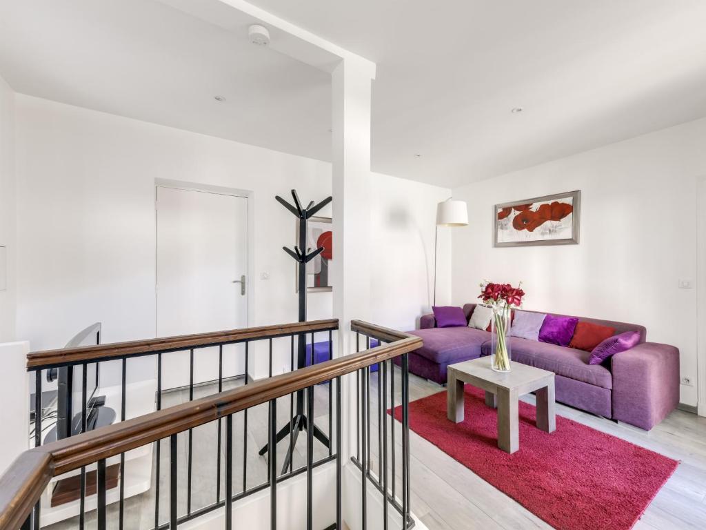 a living room with a purple couch and a table at Loft Fraternité in Bagnolet