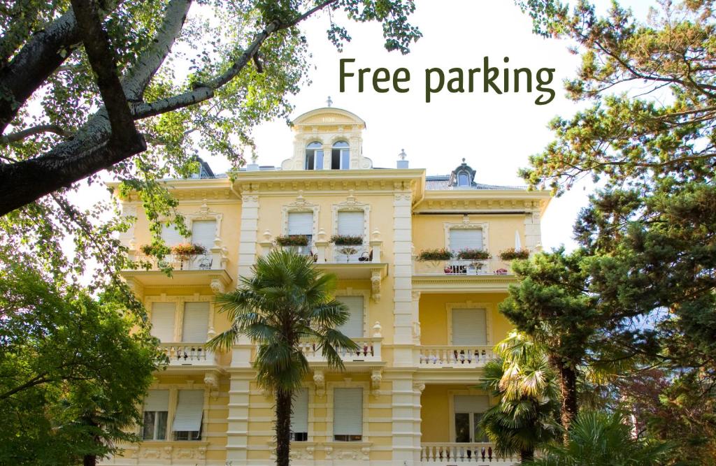 a yellow building with the words free parking at Hotel Villa Westend in Merano