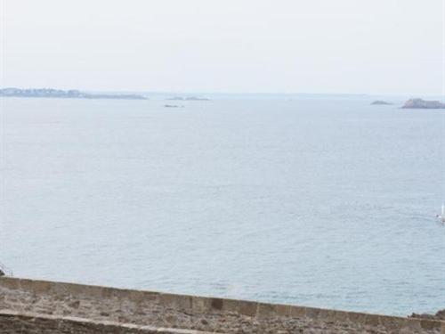 a large body of water with a person flying a kite at Intra Muros Vue Mer in Saint Malo