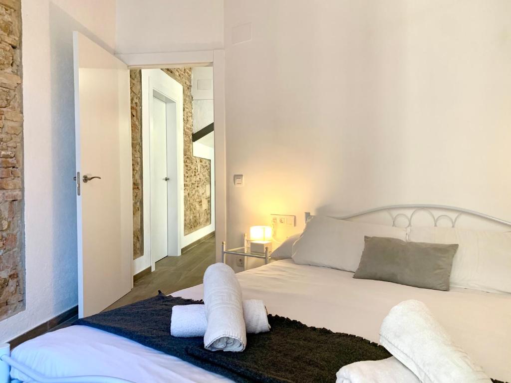 a bedroom with a white bed with towels on it at Vila Badalona in Badalona