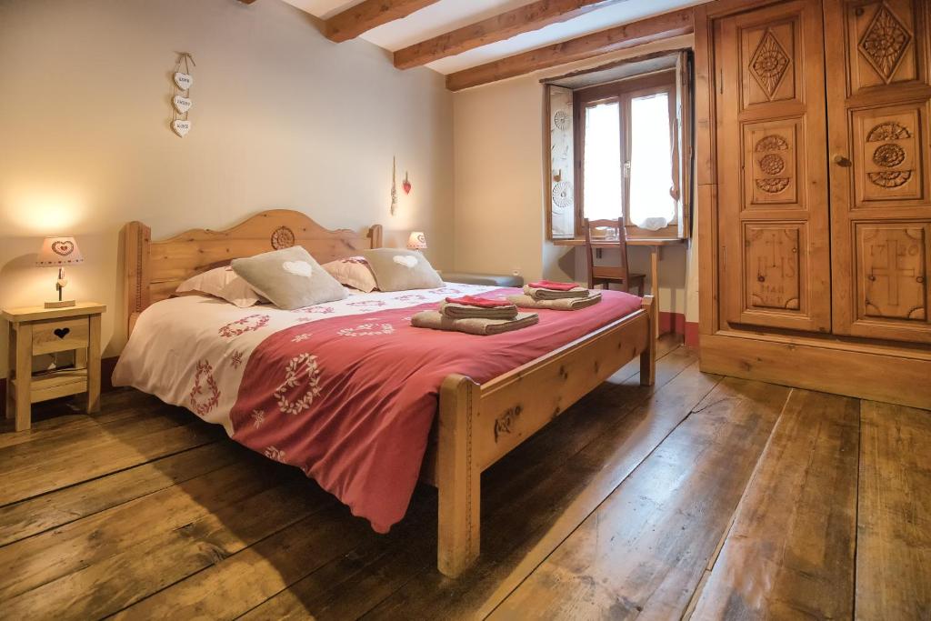 a bedroom with a wooden bed with a red blanket at Au Coeur Des Alpes in Villarodin-Bourget