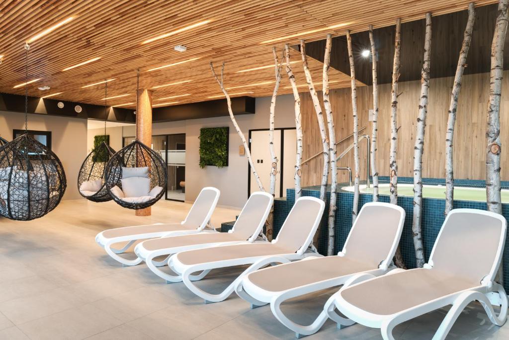 - une rangée de chaises blanches dans une salle d'attente dans l'établissement Hotel Grey Spa, à Szklarska Poręba