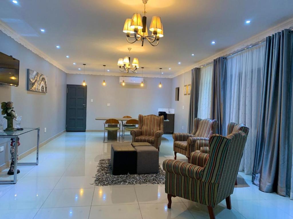 a living room with chairs and a dining room at Airport lodge Newcastle in Newcastle