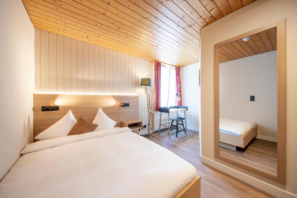 Postel nebo postele na pokoji v ubytování Hotel Kreuz & Post Grindelwald