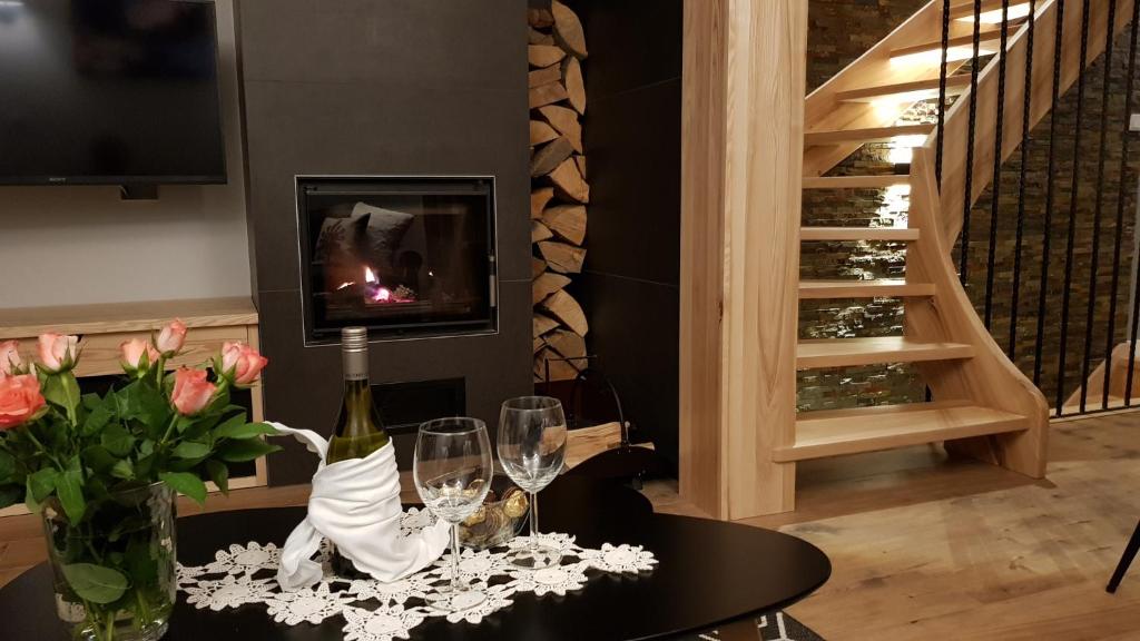 a room with a table with wine glasses and flowers at Biathlon Park - Apartament VIP in Kościelisko