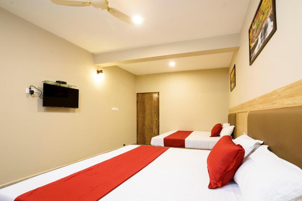 a bedroom with two beds and a flat screen tv at Casa Da Village Calangute Goa in Calangute