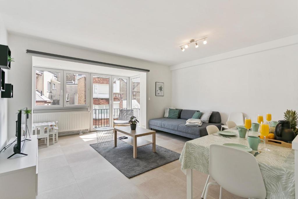 ein Wohnzimmer mit Sofa und Tisch in der Unterkunft Flat Antoine in De Panne