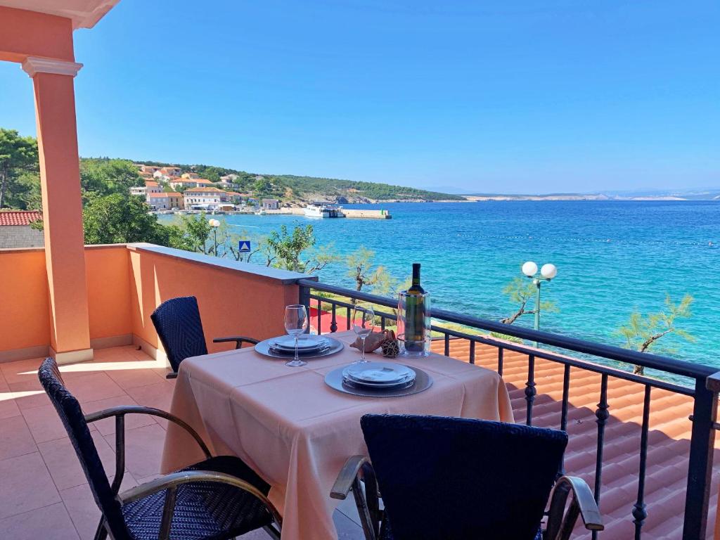 a table on a balcony with a view of the water at Apartments Beach in Šilo