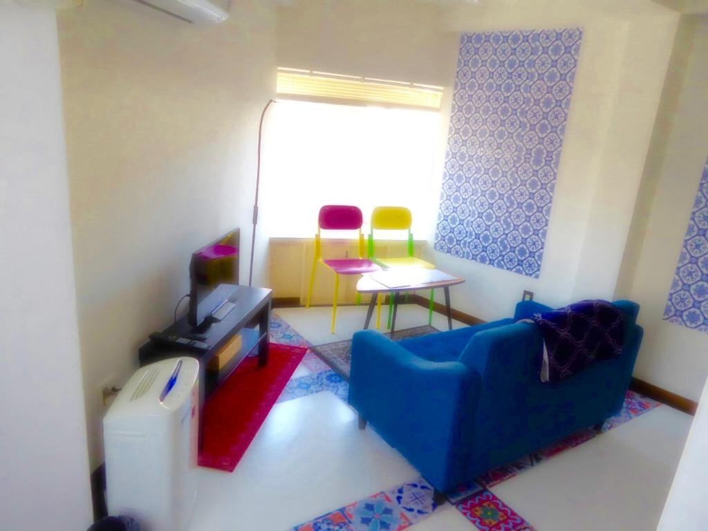 a living room with a blue couch and two chairs at Dazaifu - Apartment / Vacation STAY 36901 in Dazaifu
