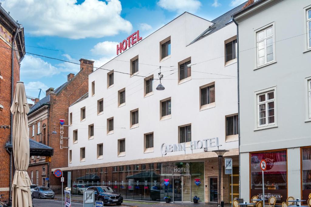 a large white building on a city street at Cabinn Aarhus in Aarhus