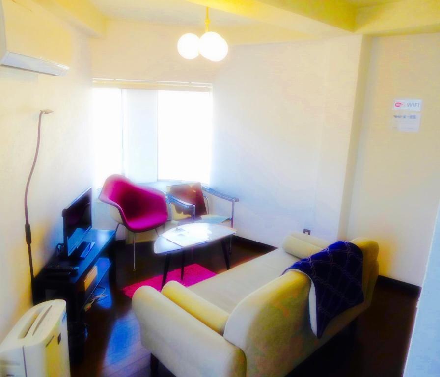 uma sala de estar com um sofá e uma mesa em Dazaifu - Apartment / Vacation STAY 36942 em Dazaifu