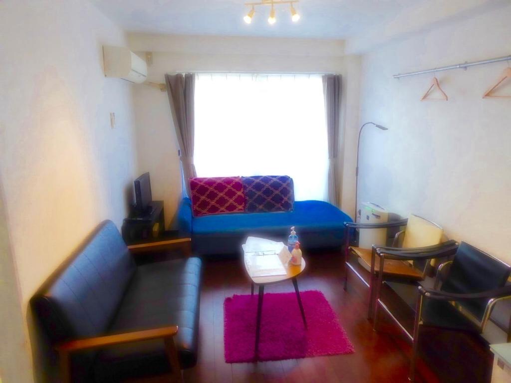 uma sala de estar com um sofá azul e uma janela em Dazaifu - Apartment / Vacation STAY 36943 em Dazaifu