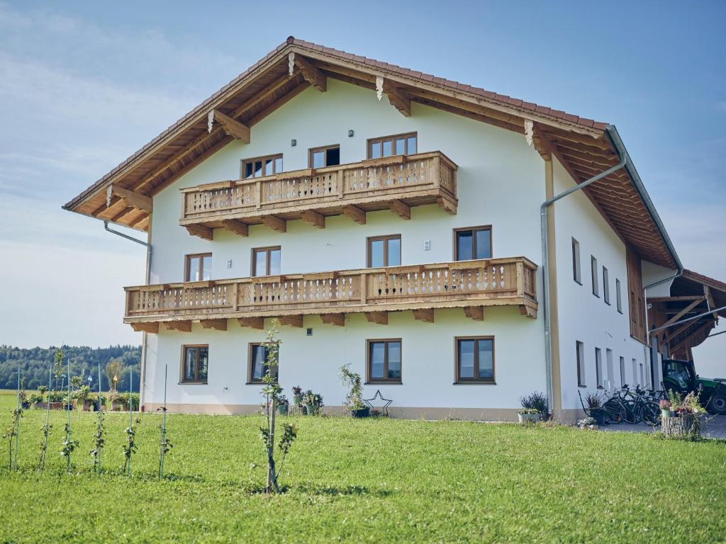 a large white house with a wooden balcony at Lehnerhof in Bad Aibling