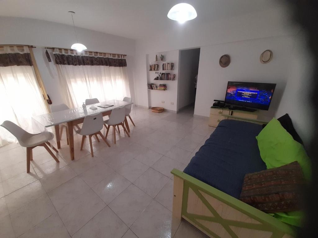 uma sala de estar com um sofá, uma mesa e uma televisão em Sueños del Golfo em Puerto Madryn