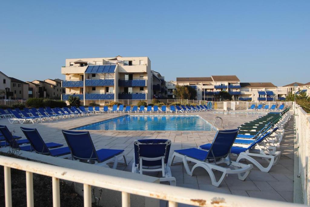 una fila de sillas y una piscina en el balcón en Les Pieds dans l'Eau en Lacanau-Océan
