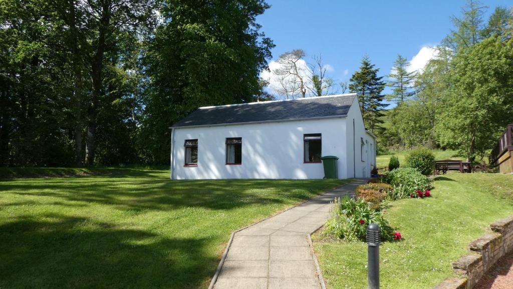 a white tiny house in a yard at Foxglove Cottage in Maybole