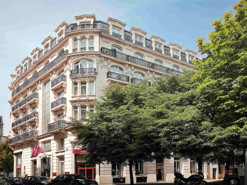 - un grand bâtiment avec des balcons sur le côté dans l'établissement Mercure Lille Centre Grand Place, à Lille