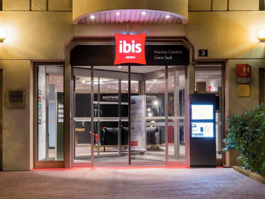 una entrada a un edificio con letreros en él en ibis Nantes Centre Gare Sud en Nantes