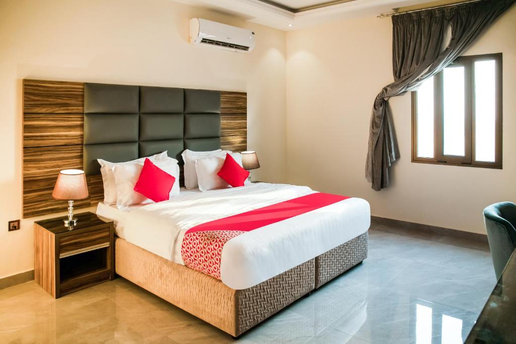 um quarto com uma cama grande e almofadas vermelhas em Durra Taraf Residential 2 em Dammam