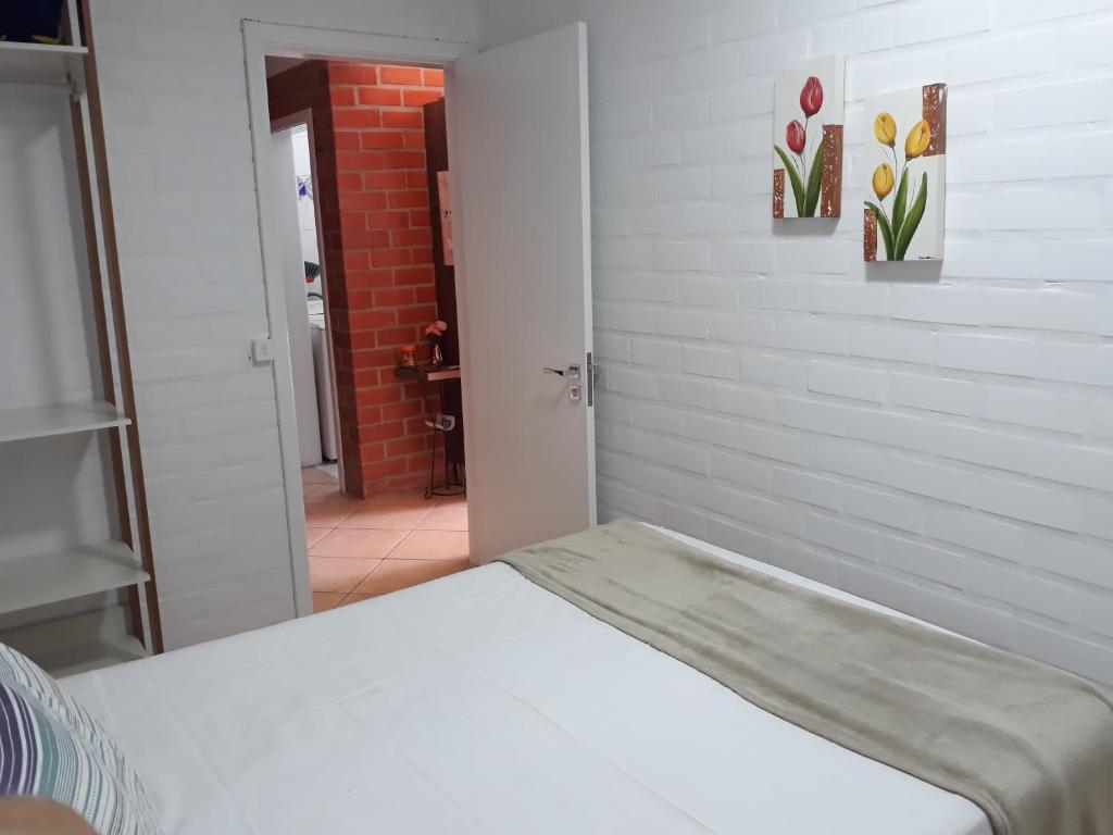 Pokój z łóżkiem i ceglaną ścianą w obiekcie Lar do Vale - Vinhedos w mieście Bento Gonçalves
