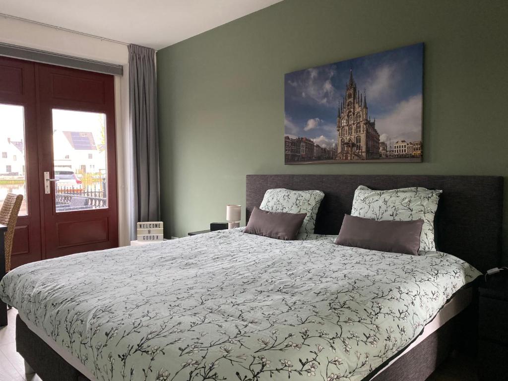 een slaapkamer met een bed met een foto aan de muur bij Gouda's Herenhuys in Gouda