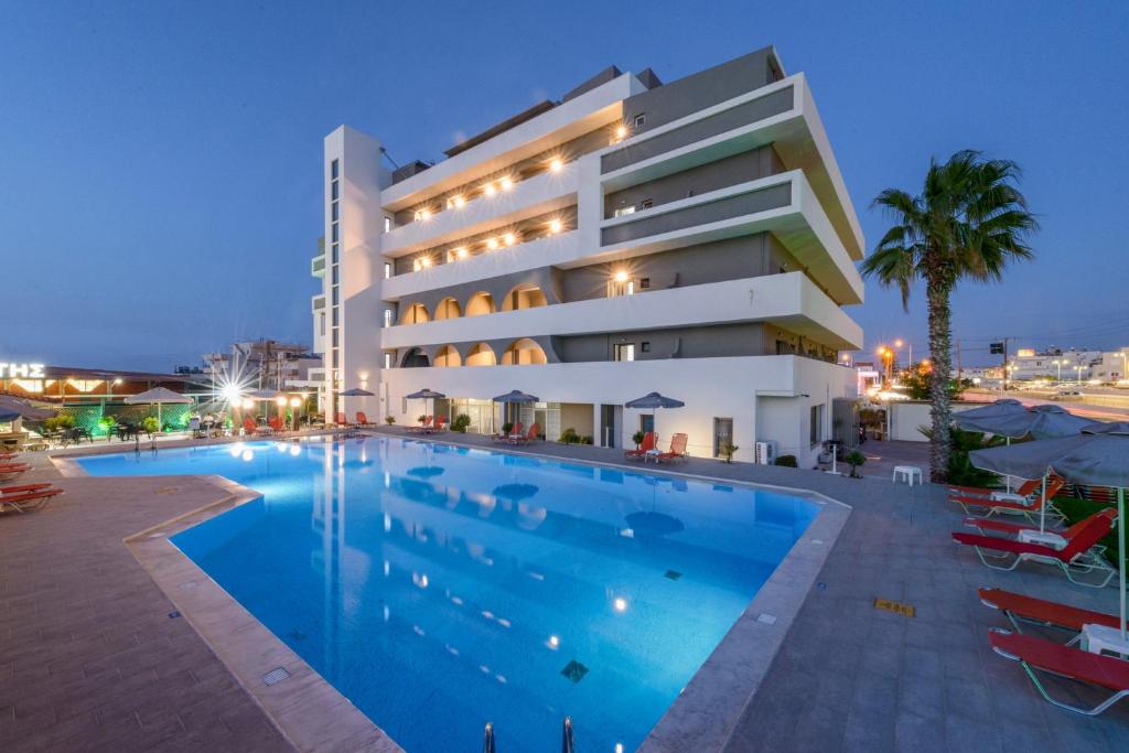 a hotel with a swimming pool in front of a building at Vanisko Hotel in Amoudara Herakliou