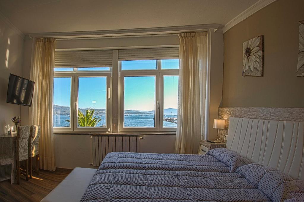 1 dormitorio con cama y ventana grande en Hotel a Muradana, en Muros