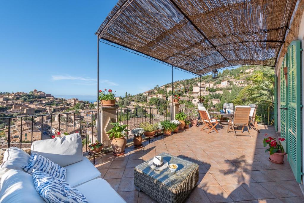 a patio with a couch and chairs on a balcony at SA VOLTA DE C'AN OLIVER in Deia