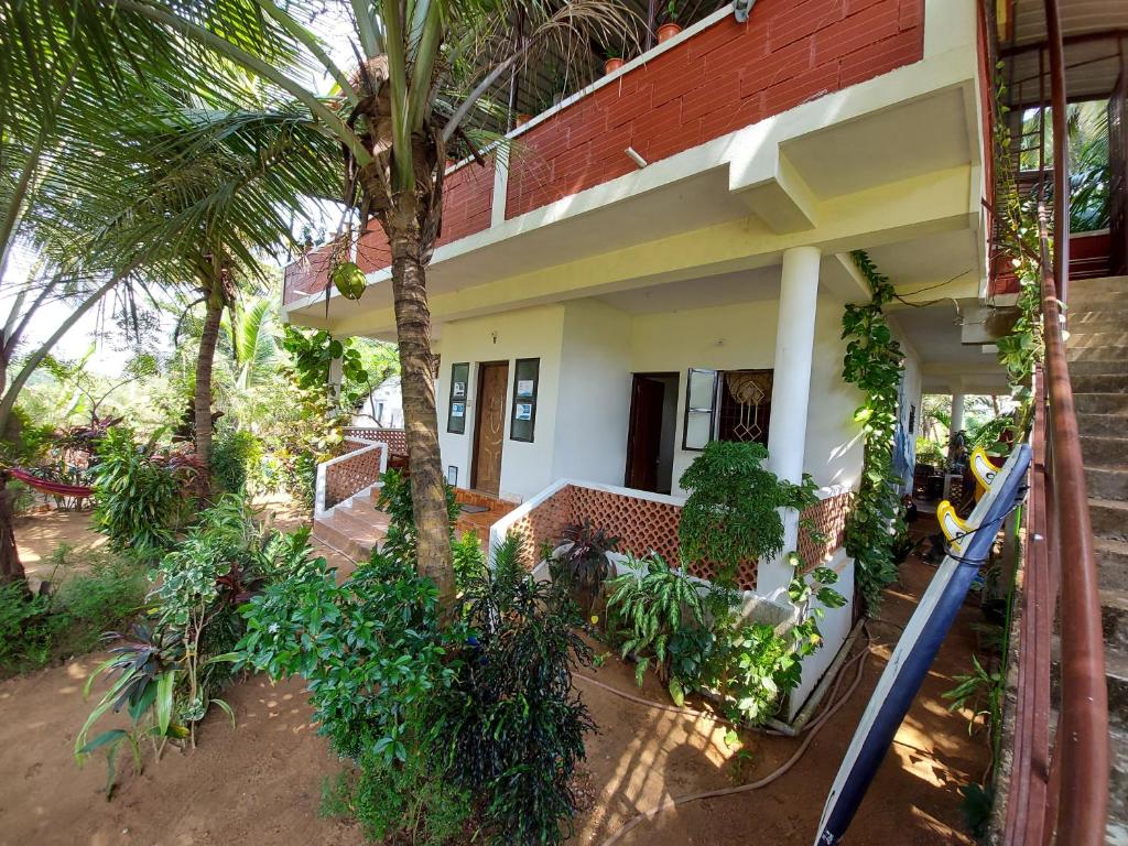 a house with a palm tree in front of it at Cocopelli Guest House in Gokarna