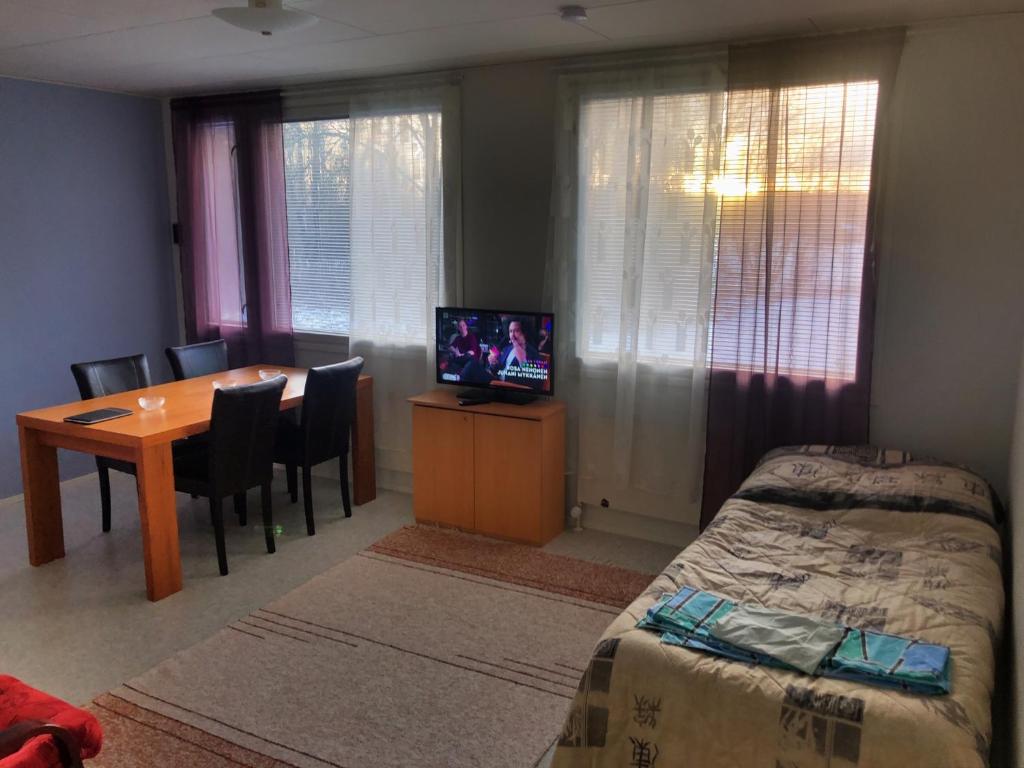 a bedroom with a bed and a table with a television at Salonkylän koulu in Kaustinen