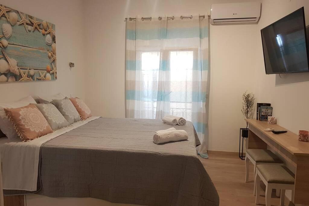 a bedroom with a bed with two towels on it at Modern elegant apartment next to Mon Repo in Corfu