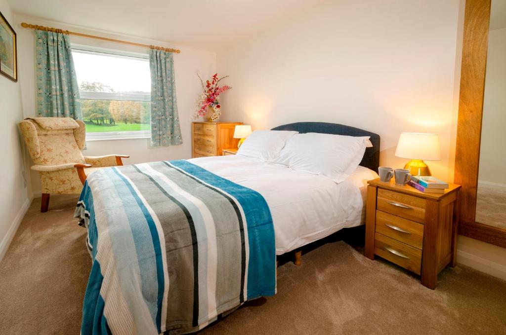 a bedroom with a bed and a chair and a window at Quarry Bank in Chapel Stile