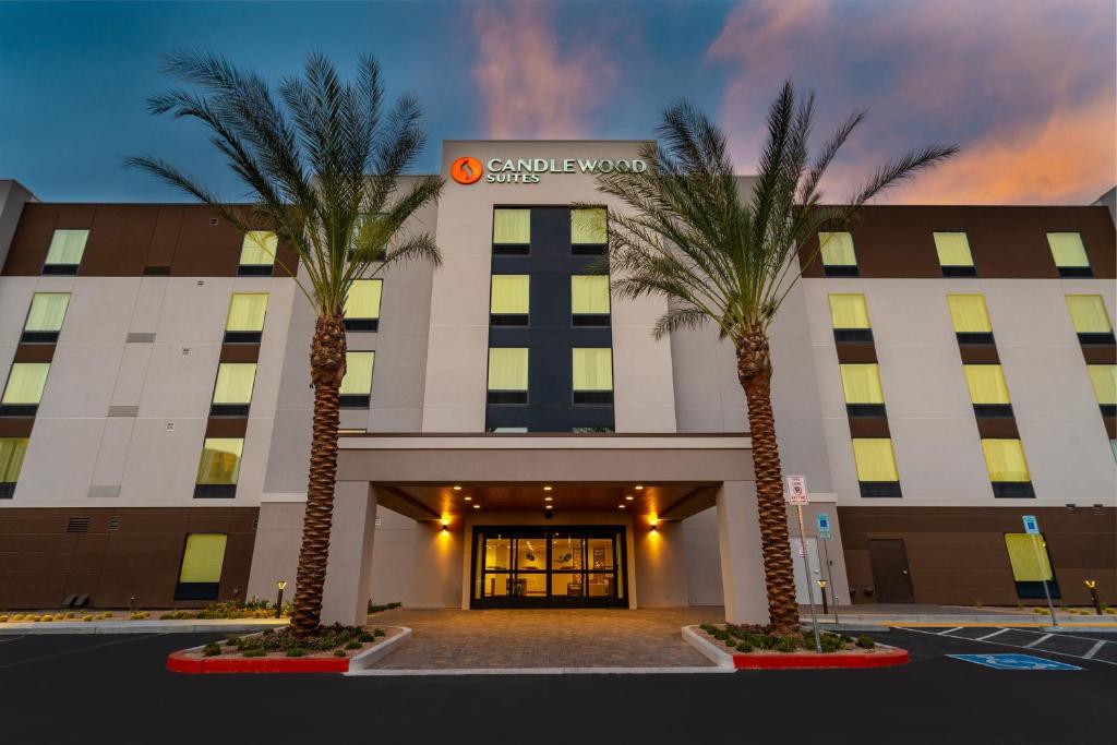 a hotel with two palm trees in front of it at Candlewood Suites - Las Vegas - E Tropicana by IHG in Las Vegas