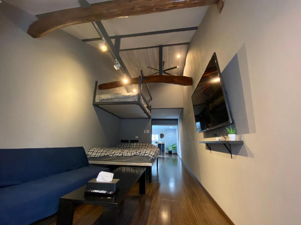 a living room with a blue couch and a table at Family Room Okinawa in Makishimachi