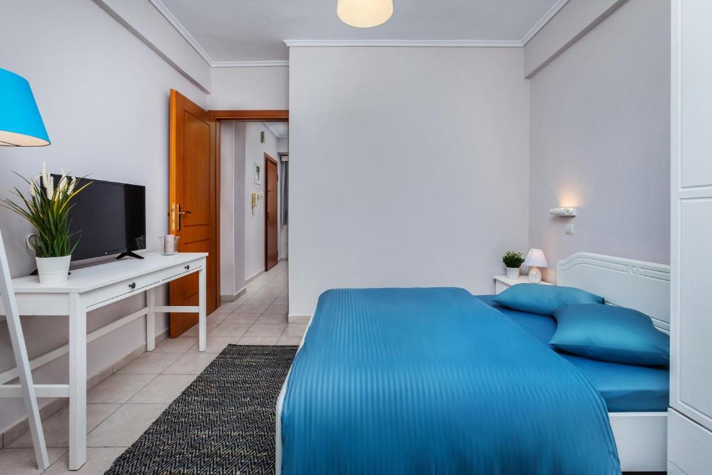 - une chambre avec un lit bleu et un bureau dans l'établissement Charlot House, à Thessalonique