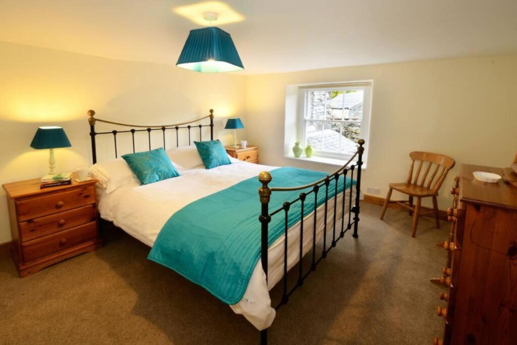 Un dormitorio con una cama grande y una ventana. en Stickle Cottage, Great Langdale, en Grasmere