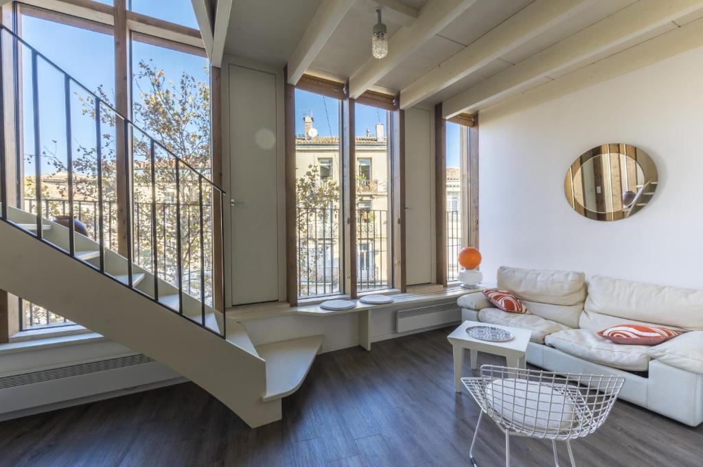- un salon avec un canapé et des fenêtres dans l'établissement Duplex En Aparté - Première conciergerie, à Montpellier