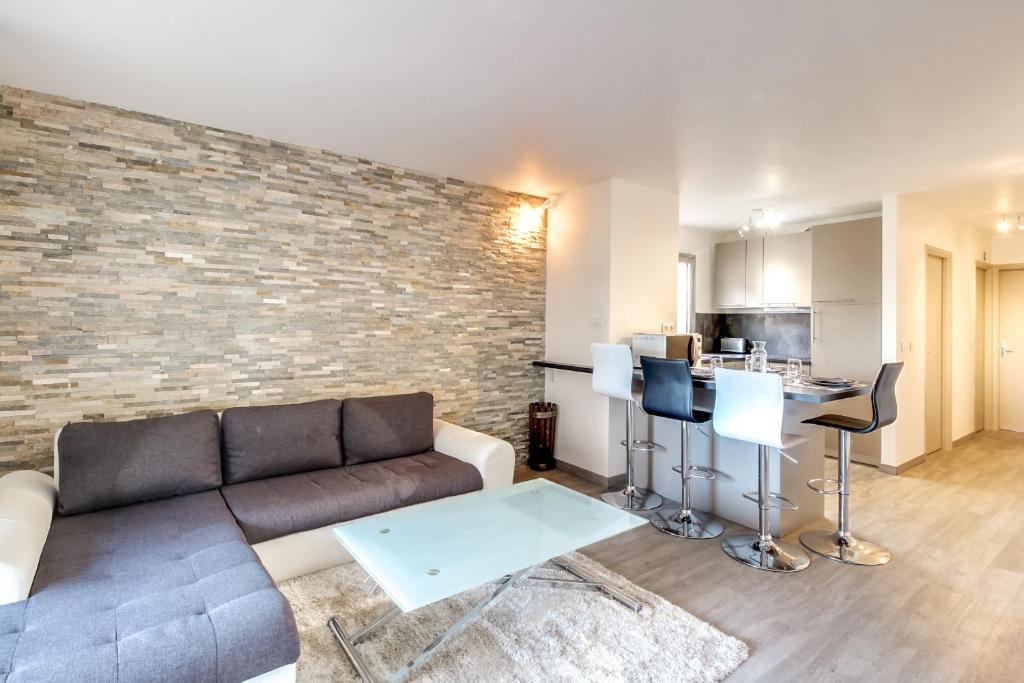 un salon avec un canapé et un mur de briques dans l'établissement IMMOGROOM- Renovated - Wifi - Close to everything, à Cannes