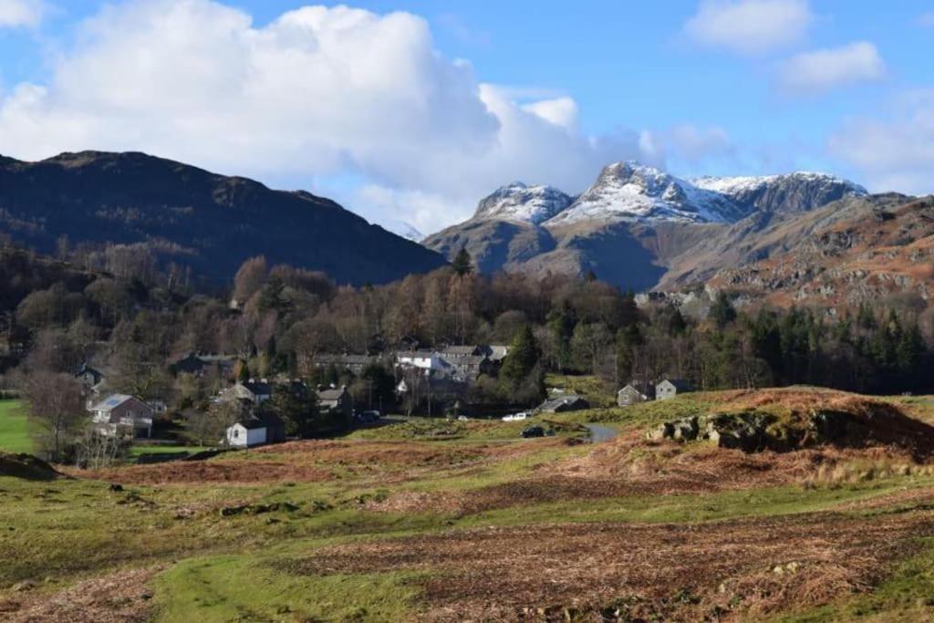 a village in a mountain valley with snow capped mountains at The Stables, Elterwater in Elterwater